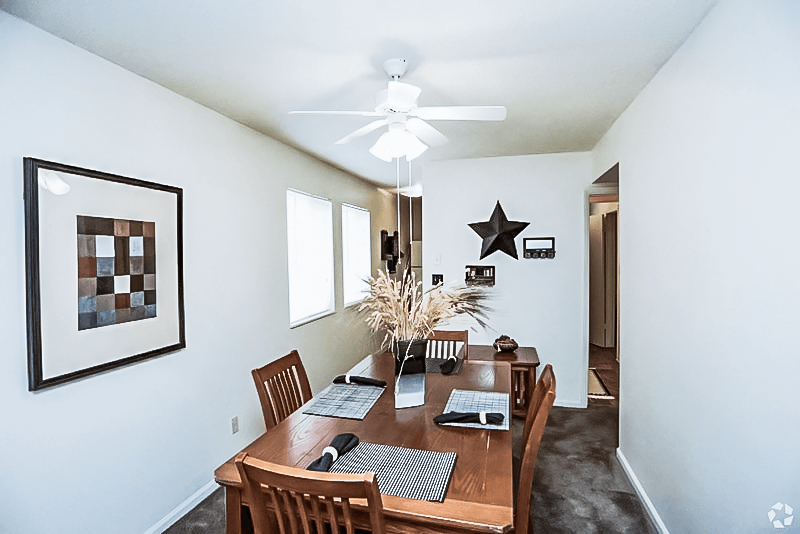 a dining room with a wooden table and a ceiling fan at Gatehouse Apartments, Kansas City, MO, 64134