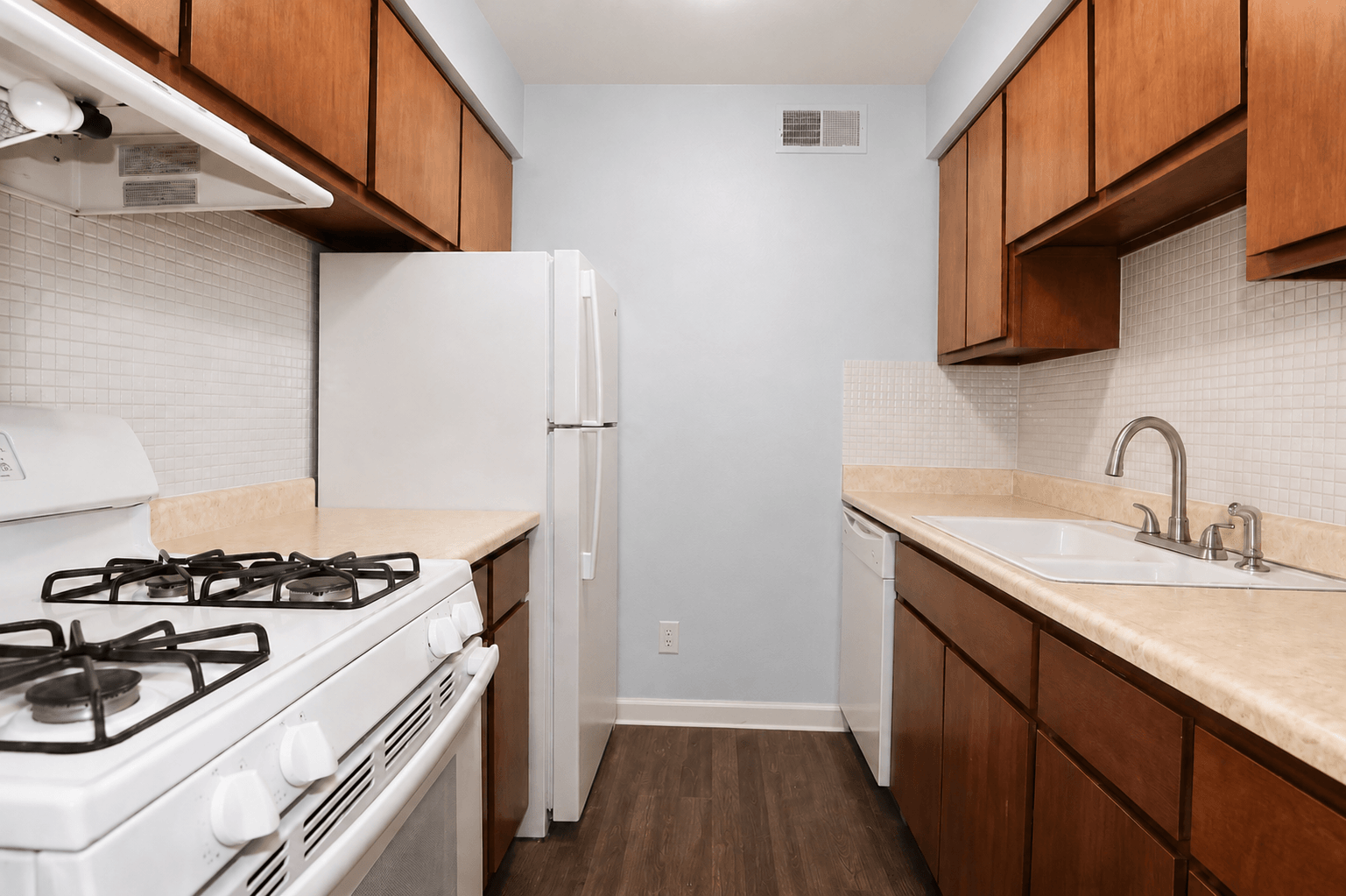 A kitchen with a white gas stove and wooden cabinets.