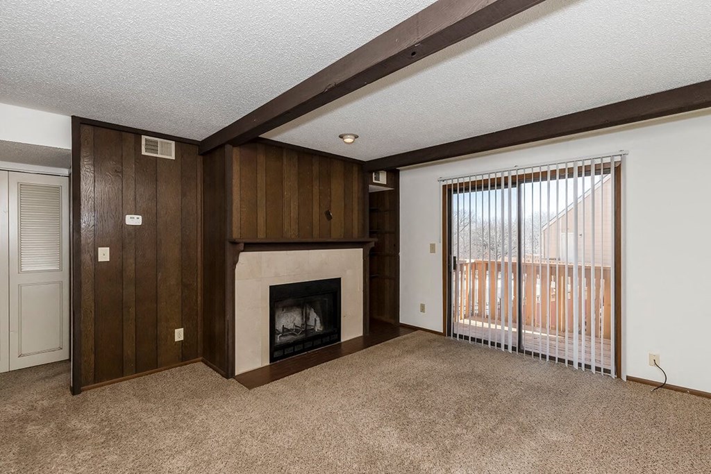West One Bedroom Living Room, Fireplace, and Balcony Door at Raintree Apartments, Topeka, KS, 66614