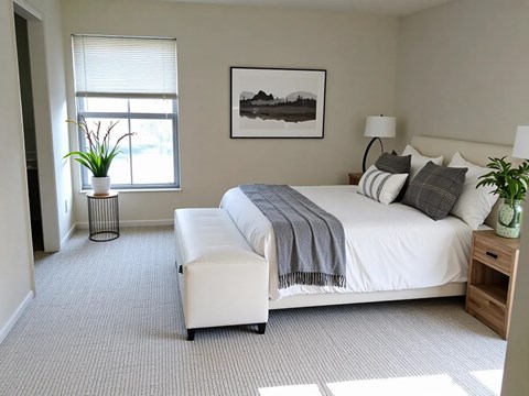 A bedroom with a large bed and a painting on the wall.