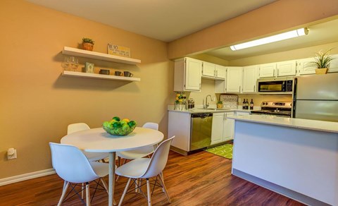 a kitchen with a white table and chairs