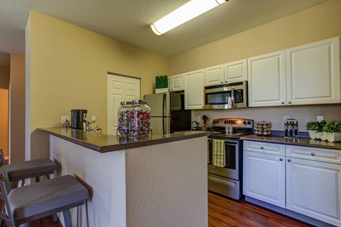 A kitchen with white cabinets and a white oven.