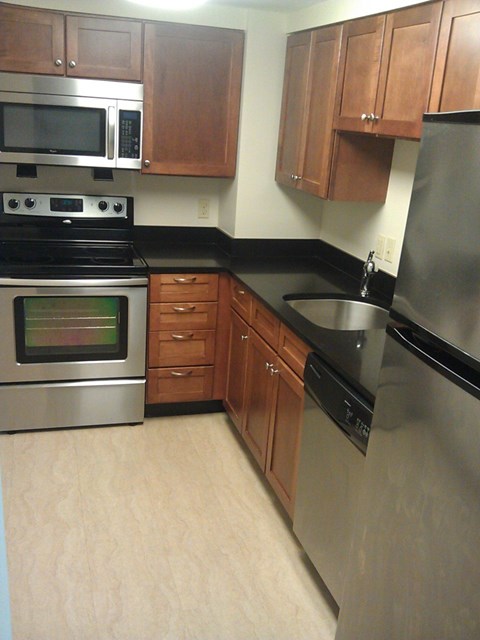 A kitchen with wooden cabinets and stainless steel appliances.