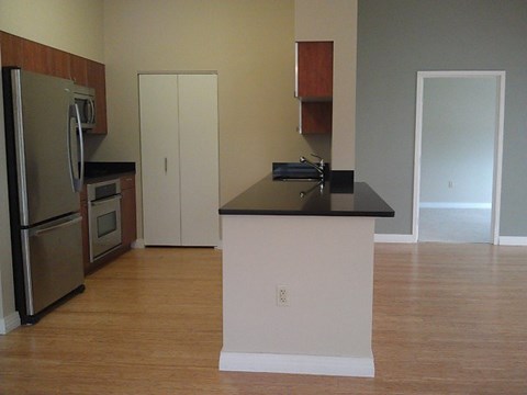 A kitchen with a black counter top and white cabinets.