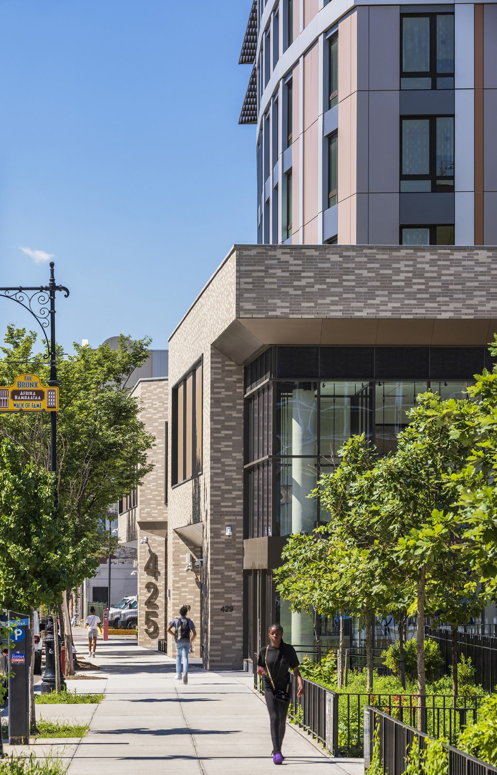 people walking down a sidewalk in front of a building