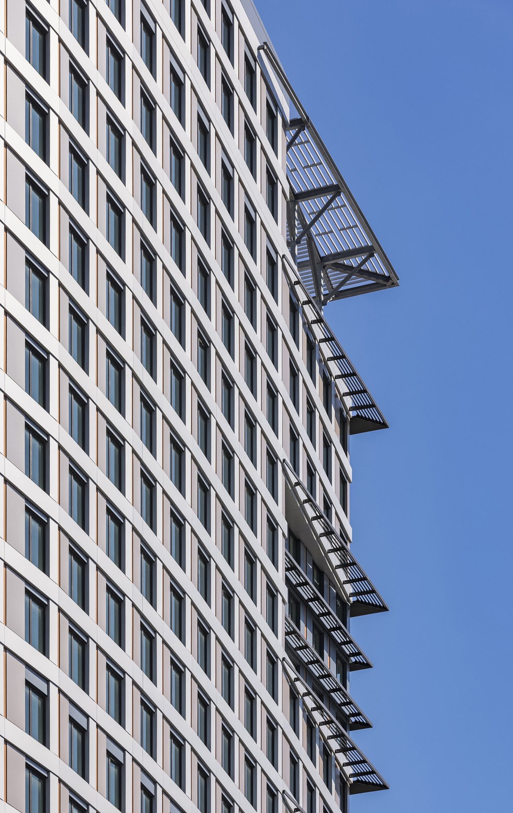 a tall building with balconies and a blue sky