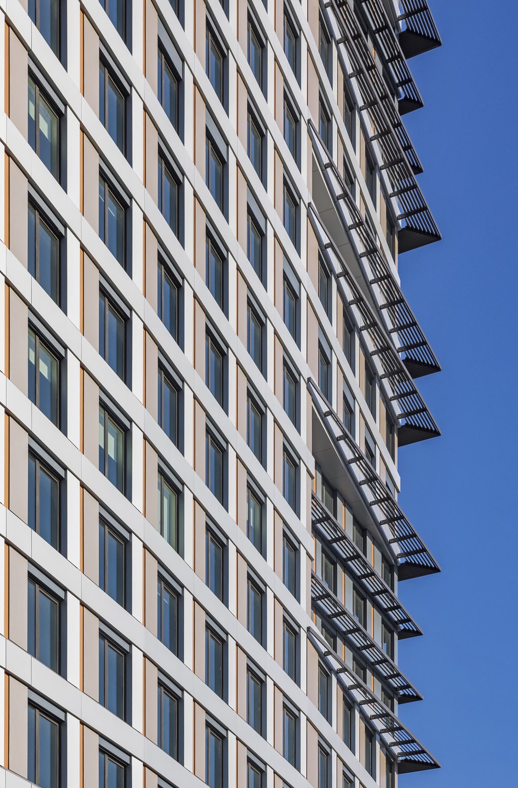a tall building with many windows and a blue sky