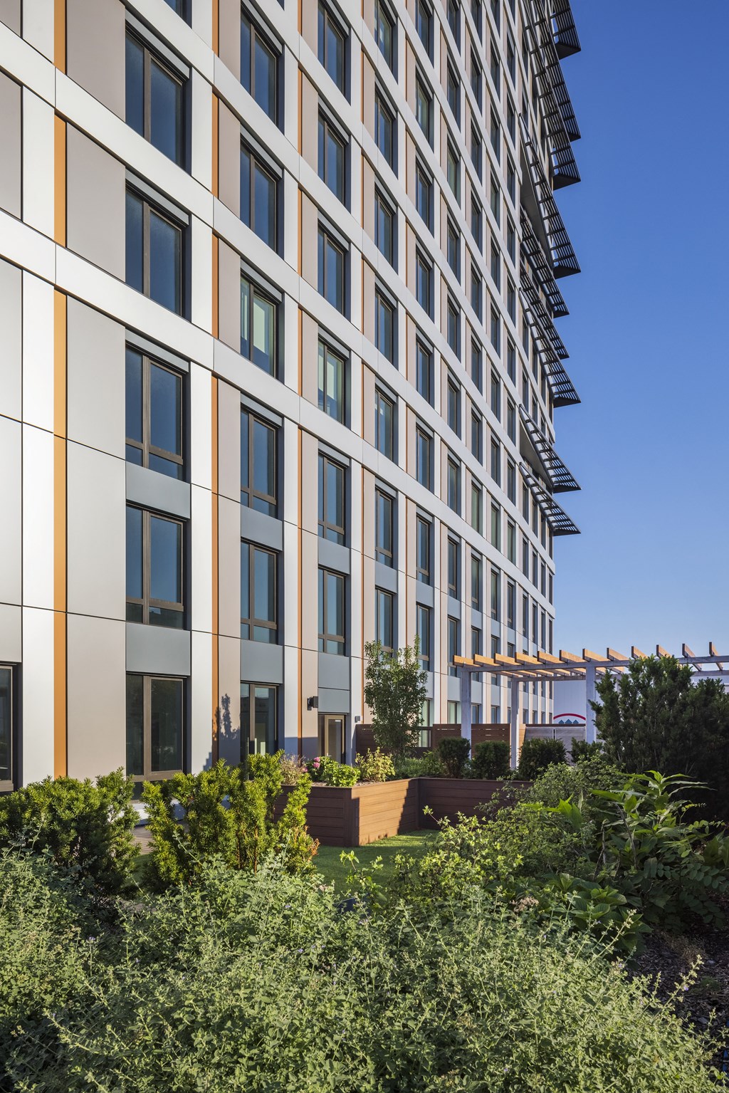a tall building with a garden in front of it