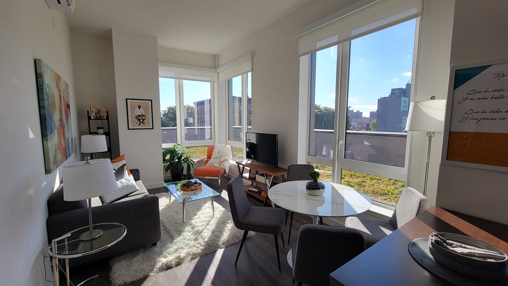 a living room with a large window and a table and chairs