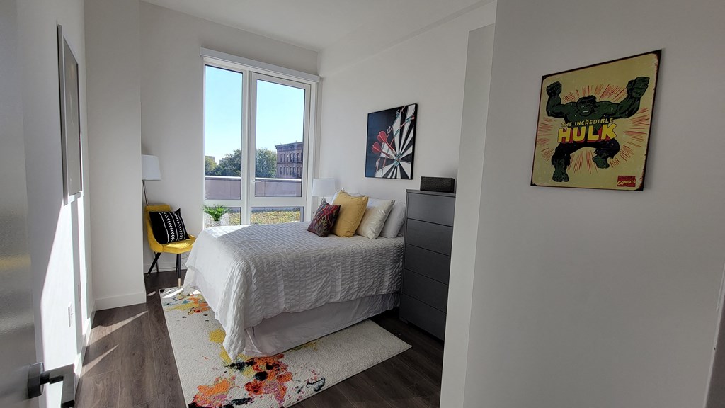 a bedroom with a bed and a large window