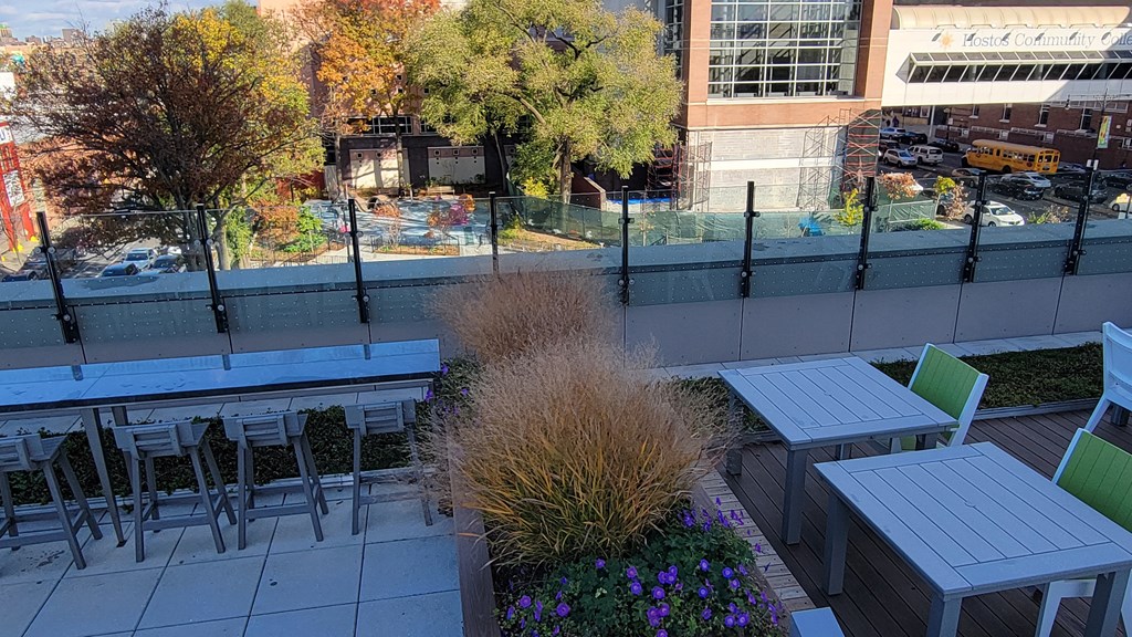 a patio with tables and chairs on top of a building