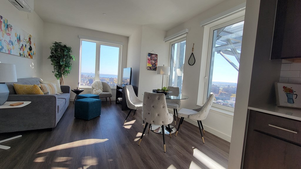 an open living room and dining room with a view of the city