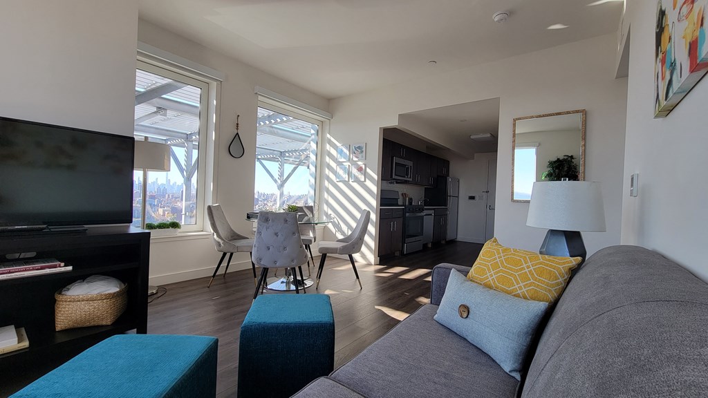 a living room and dining room with a couch and a tv