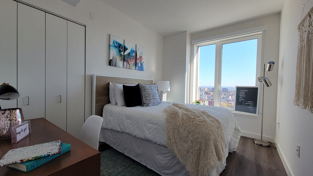 a bedroom with a bed and a large window