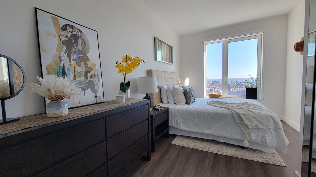 a bedroom with a bed and a dresser and a window