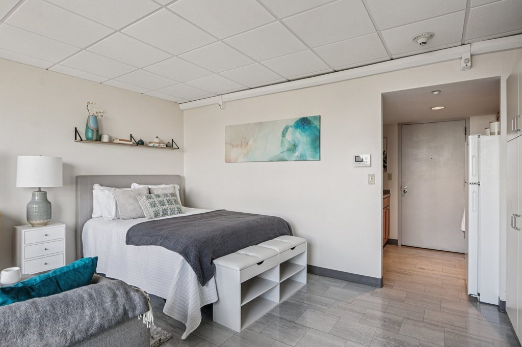 A bedroom with a bed, nightstand, and lamp.