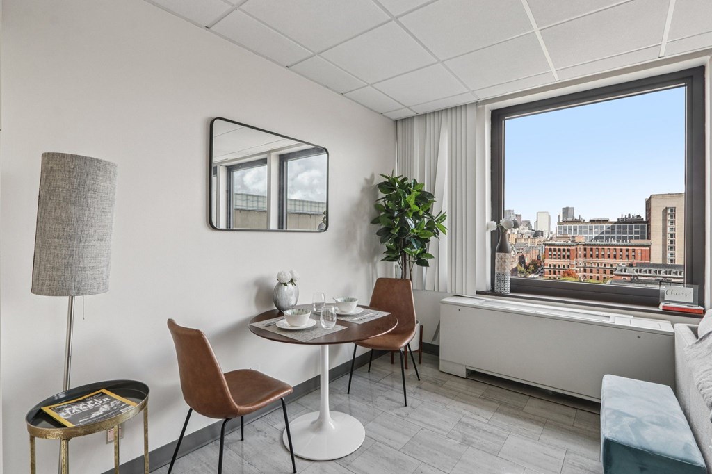 A modern dining room with a table set for two and a view of the city.