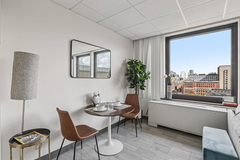A modern dining room with a table set for two and a view of the city.