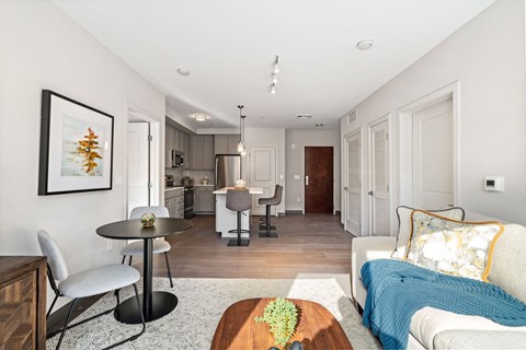 A modern living room with a dining table and chairs.