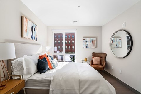 A bedroom with a large bed and a chair.