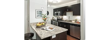 A kitchen with granite countertops and stainless steel appliances.