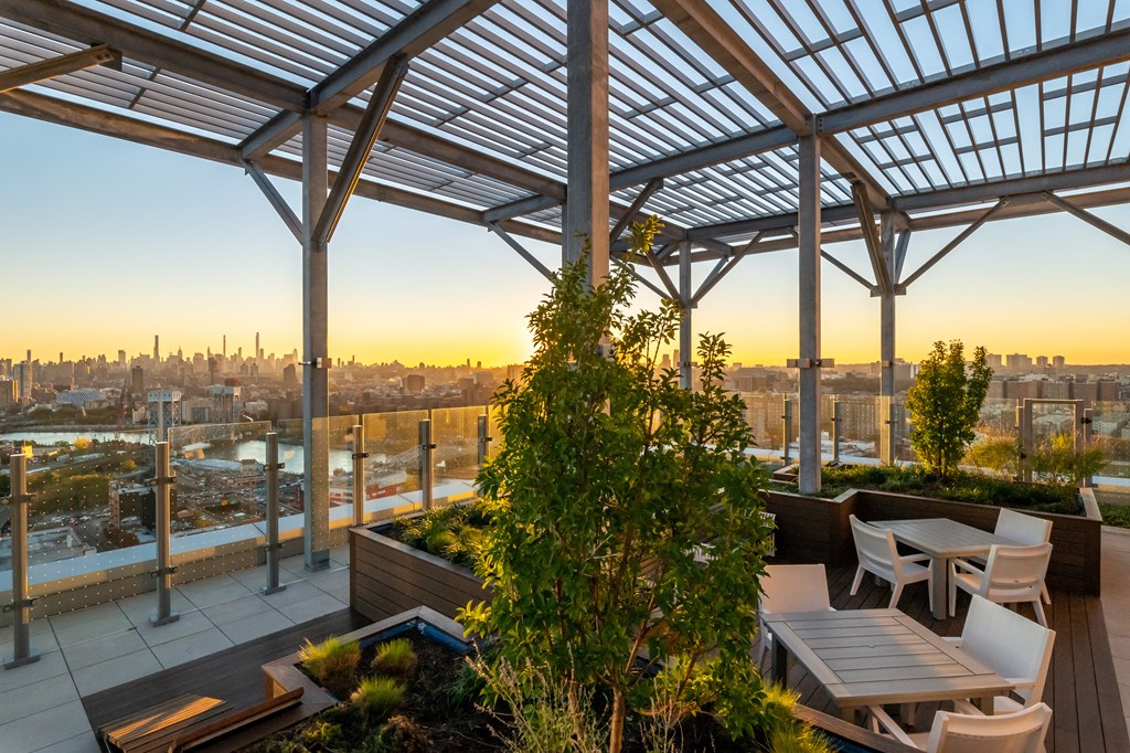 a roof terrace with tables and chairs and a view of the city