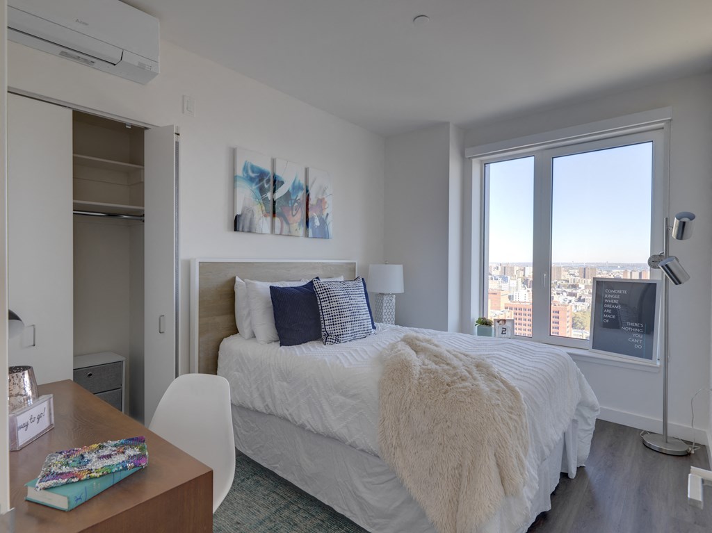 a bedroom with a bed and a desk and a window