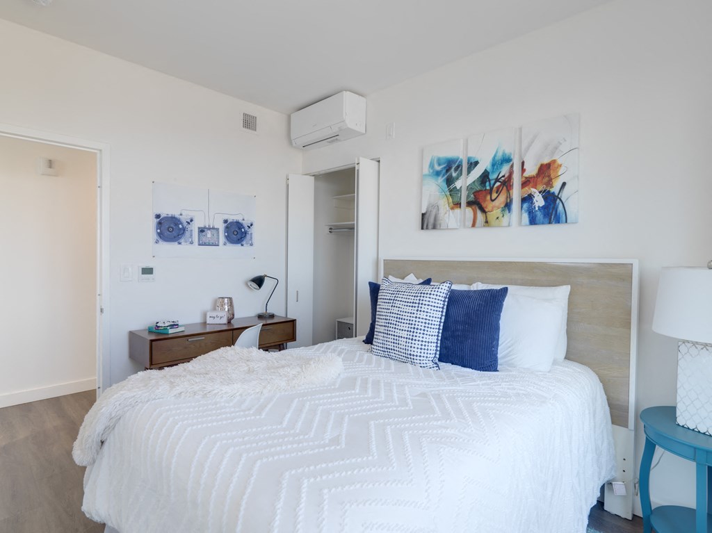 a bedroom with a white bed and blue and white pillows
