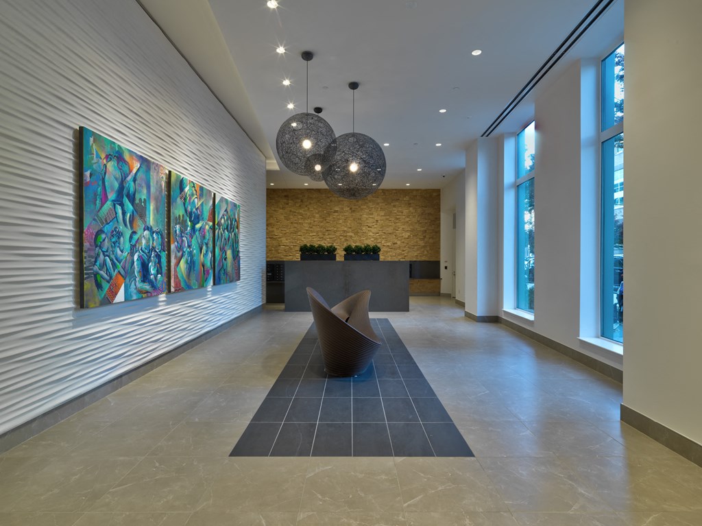 a lobby with a reception desk and a painting on the wall