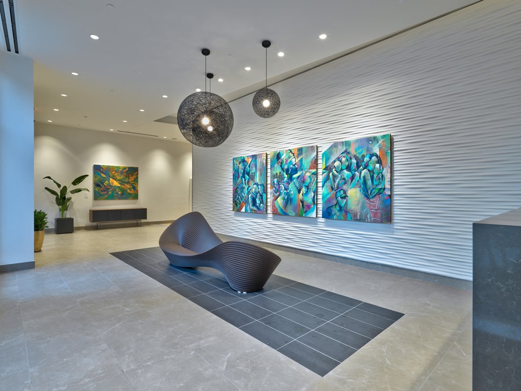a lobby with a chair and three paintings on the wall