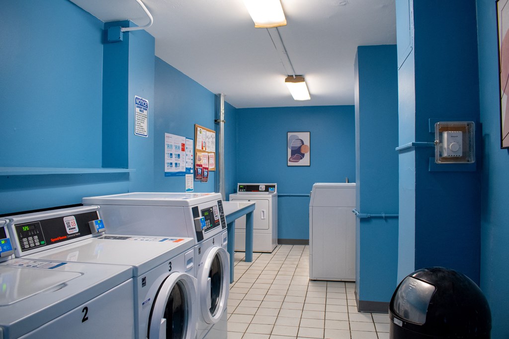a laundry room with blue walls and white tile floor