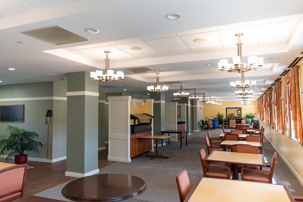 a large room with tables and chairs and chandeliers