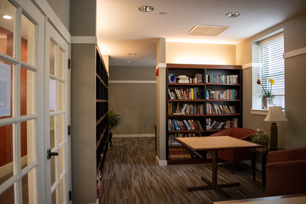 a room with a table and chairs and a bookcase filled with books