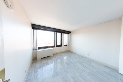 A room with a window and a radiator on the wall.