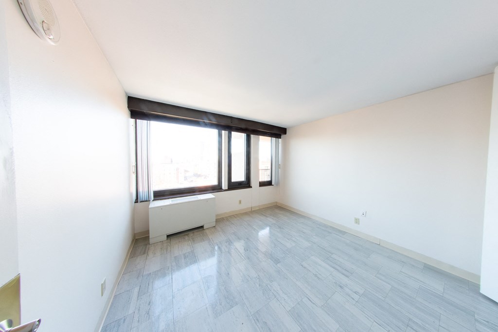 A room with a window and a radiator on the wall.