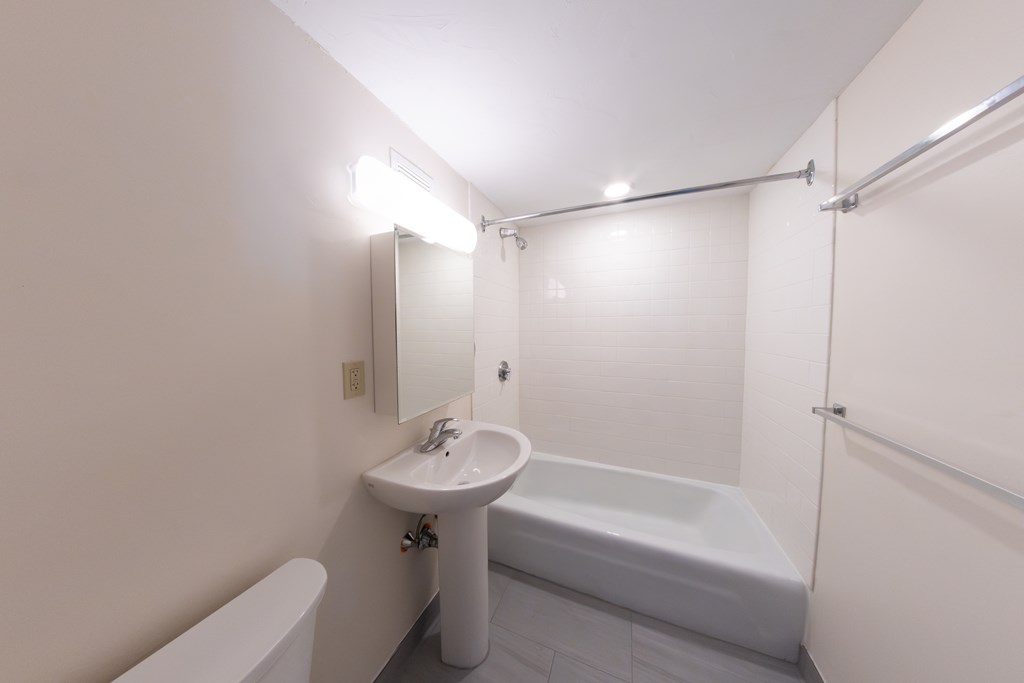 A white bathroom with a sink, toilet, and bathtub.