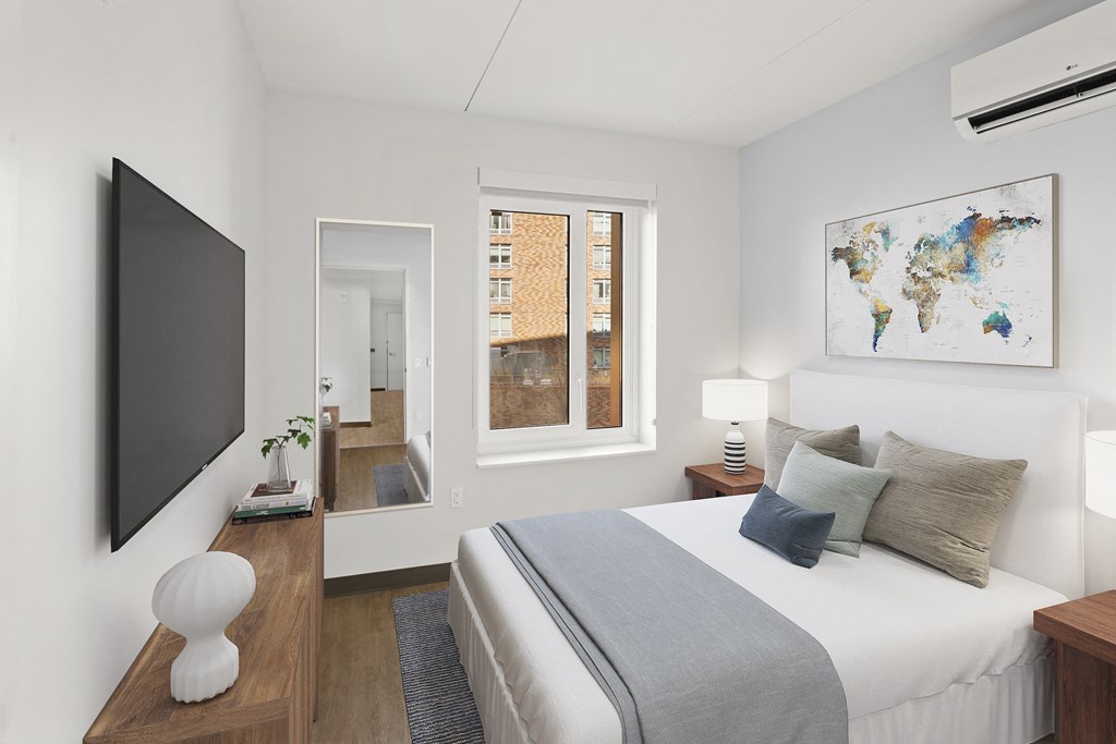 a bedroom with a large bed and a tv on the wall