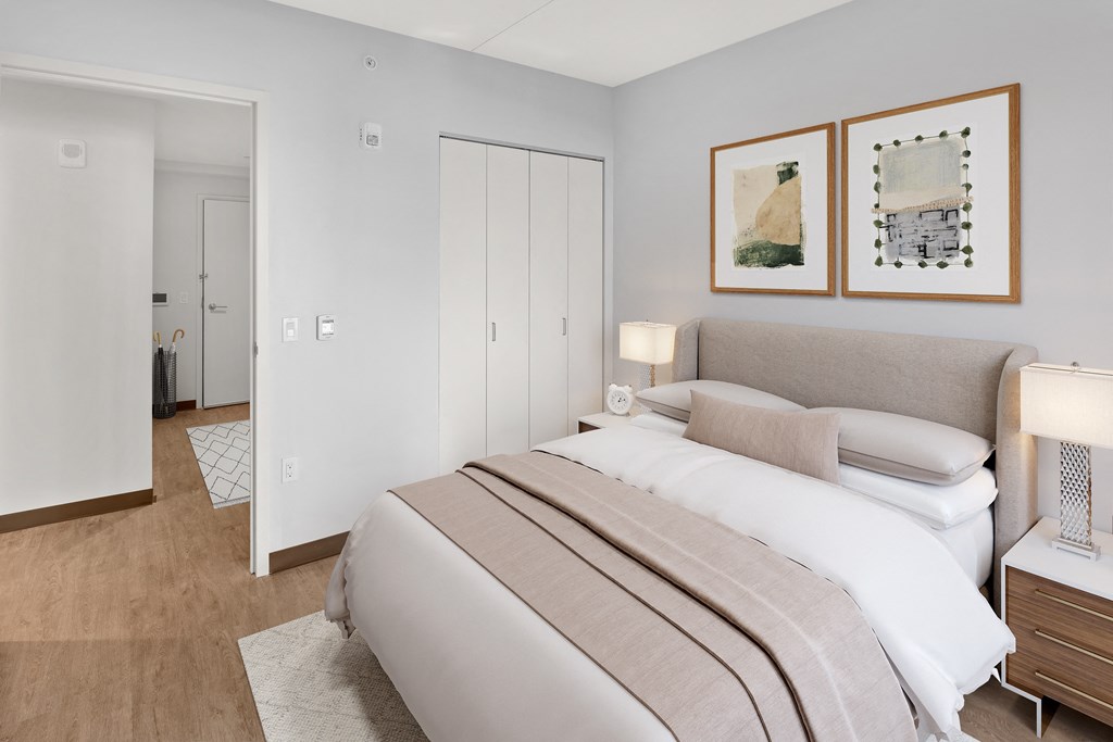 a bedroom with a bed and two paintings on the wall