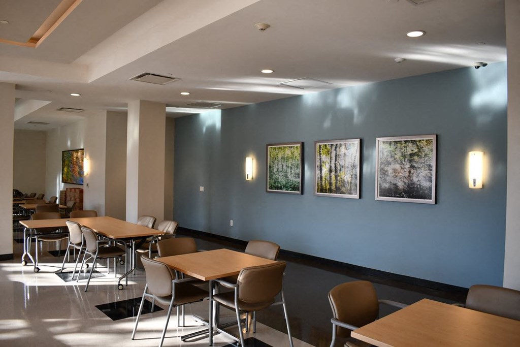 a conference room with tables and chairs and pictures on the wall