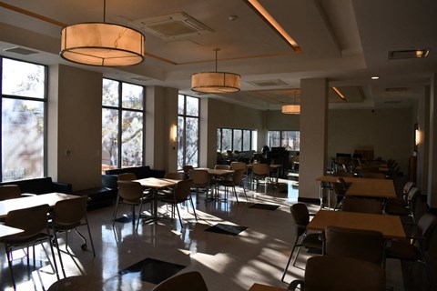 a dining room with tables and chairs and large windows