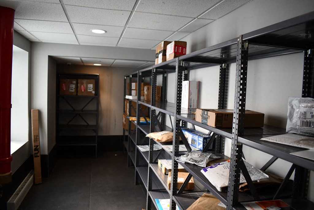 a room filled with shelves filled with boxes and furniture