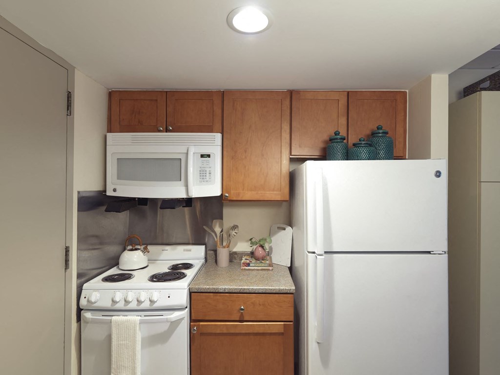 a kitchen with white appliances and wooden cabinets