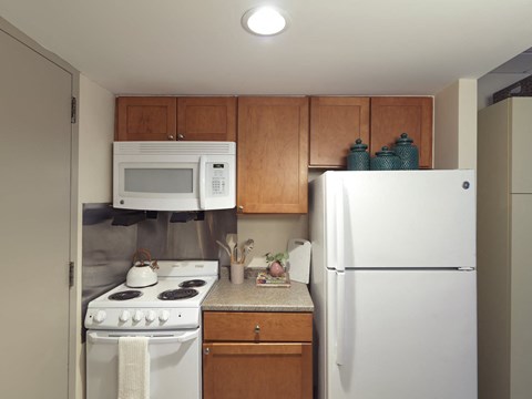 a kitchen with white appliances and wooden cabinets