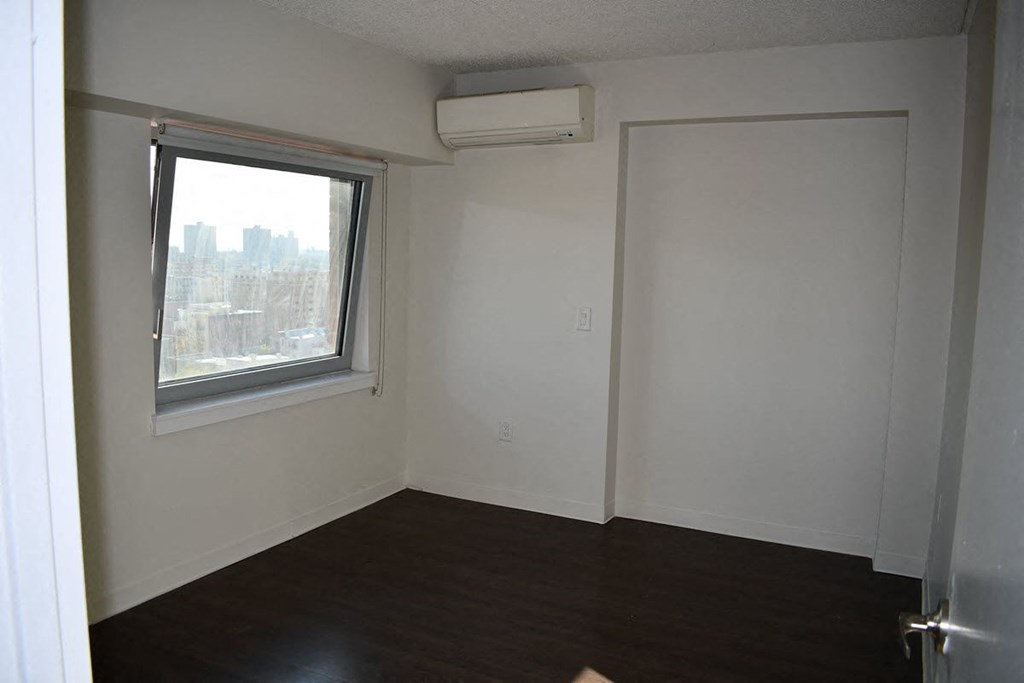 an empty room with a window and a air conditioner