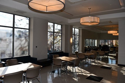 a dining room with tables and chairs and large windows