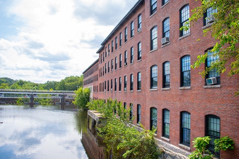 a large red brick building next to a body of water