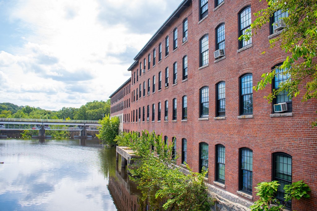 a large red brick building next to a body of water