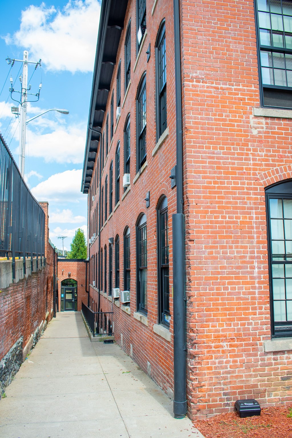 a red brick building with a black drainpipe on the side of it