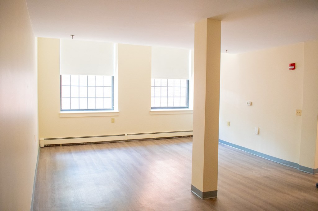 an empty room with white walls and wood floors