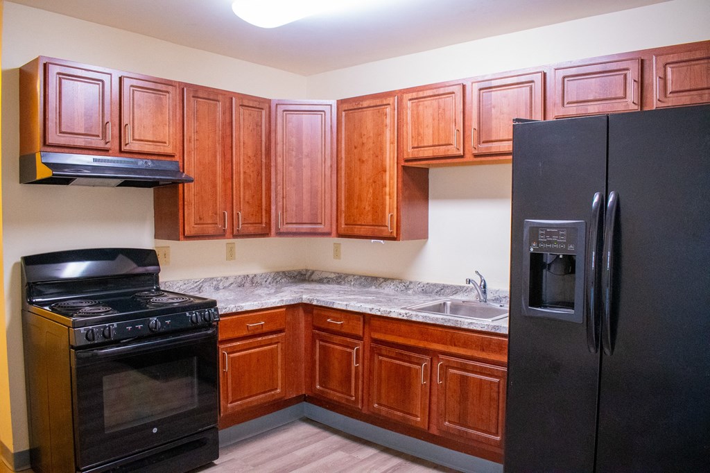 a kitchen with wood cabinets and black appliances